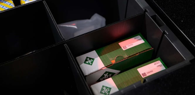 An AutoStore Bin with a pick light indicating inventory