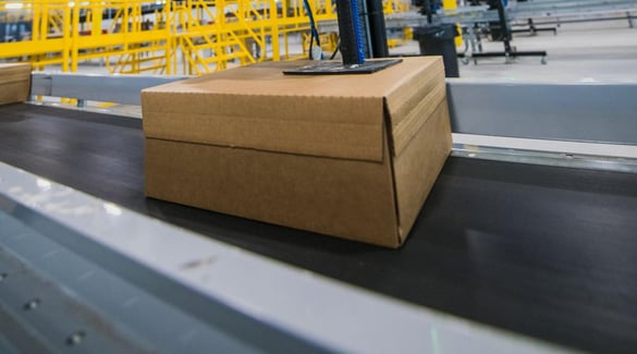 A sealed box on conveyor headed for delivery