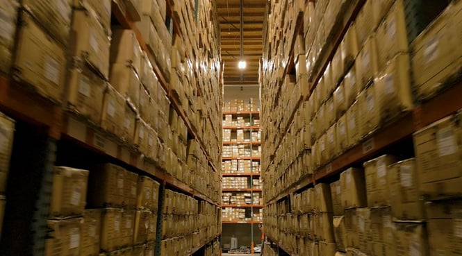 An aisle in a warehouse where boxes are stored on shelves