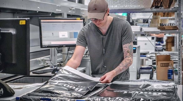 A worker adds order items to a bag at Boozt