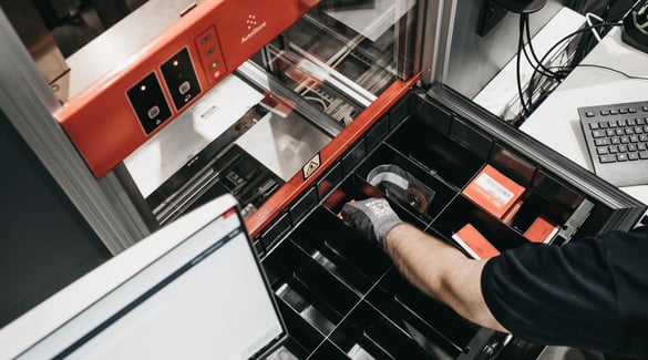 A worker selects inventory from a divided Bin
