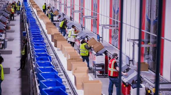 Workers fulfill orders at AutoStore workstations at PUMA