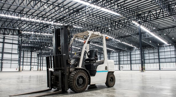 An empty forklift on a warehouse floor