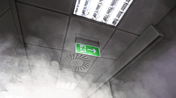 A hall with smoke and an exit sign