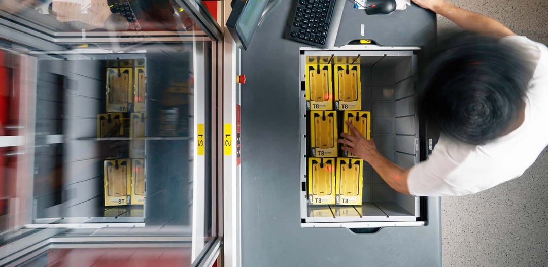 A worker sorts inventory in a Bin at a workstation