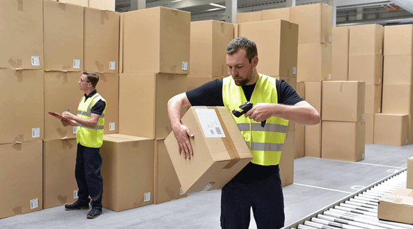 Workers in warehouse reviewing and scanning boxes
