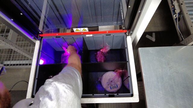 A worker picks items from an AutoStore Bin at TTI