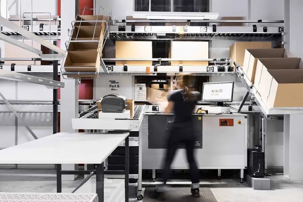 Worker at AutoStore workstation at Bergfreunde