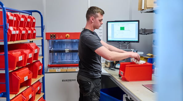 A worker sorts inventory for put away in AutoStore Grid