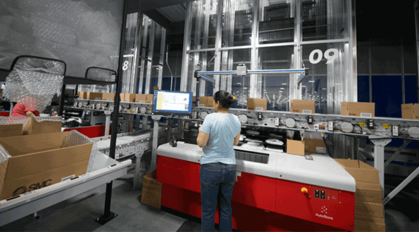 A SMC worker fulfilling orders at an AutoStore workstation