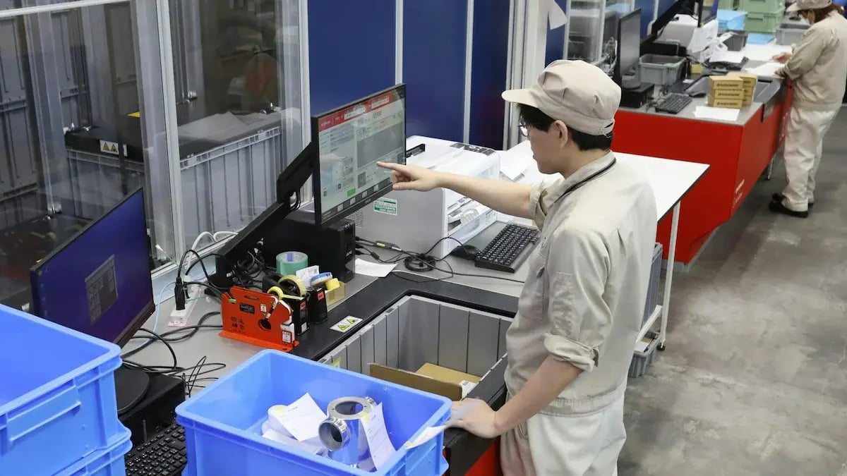 An operator using one of the AutoStore CarouselPorts. The AutoStore system has helped the working environment fore the RHEON employees with greater efficency and comfort due to the ergonomic design. 