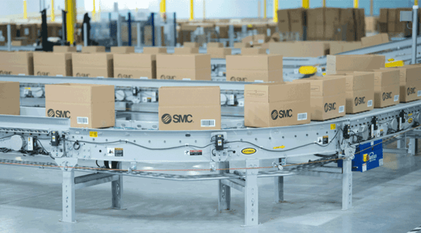 Open boxes travel along a conveyor at SMC