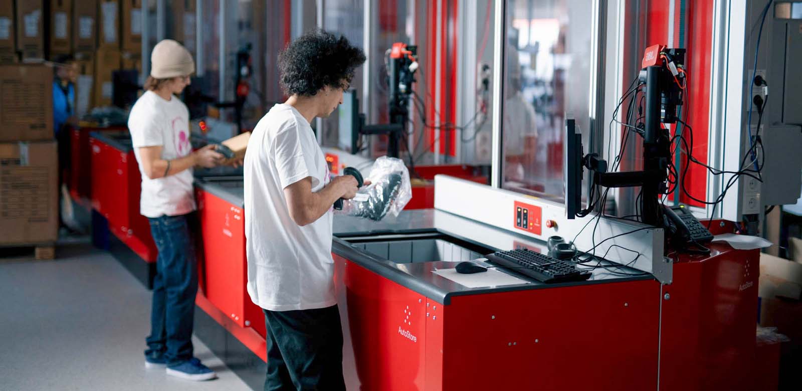 A person picking a brown package from an AutoStore pick up port
